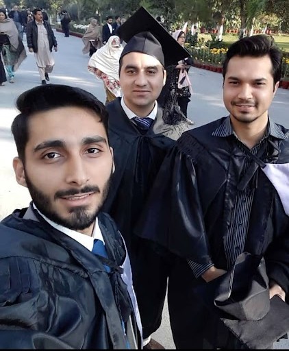 Fawad and classmates taking a selfie in graduation gowns